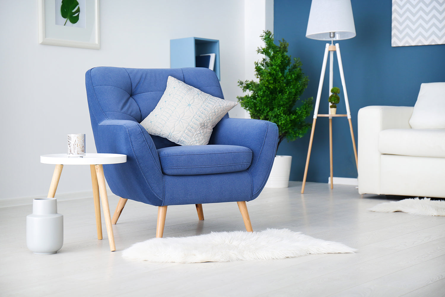 Cream machine quilted cushion with flroal motifs on a blue chair in a living room